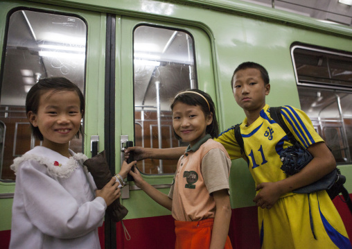 North Korean children going inside a train in a metro station, Pyongan Province, Pyongyang, North Korea