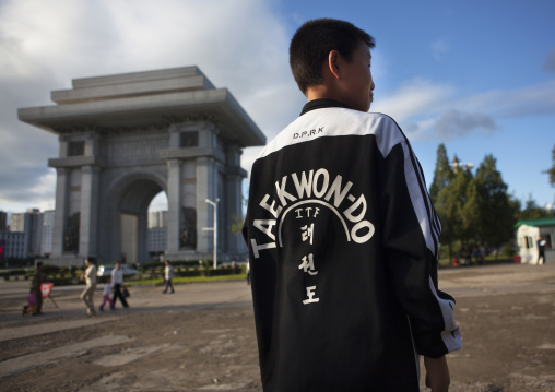 North Korean boy wearing a taekwondo shirt in front of the arch of triumph, Pyongan Province, Pyongyang, North Korea