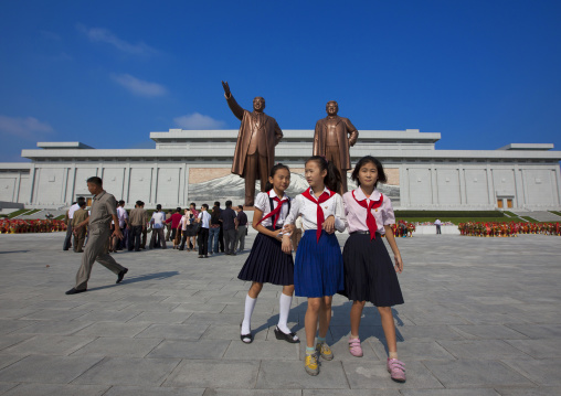 North Korean pioneers girls in front of the two statues of the Dear Leaders in the Grand monument on Mansu hill, Pyongan Province, Pyongyang, North Korea