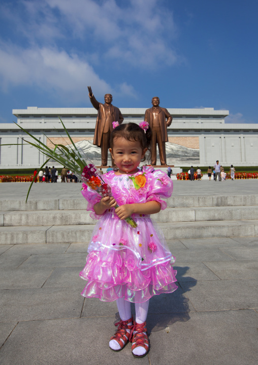 North Korean girl with flowers paying respect to the two statues of the Dear Leaders in Grand monument of Mansu hill, Pyongan Province, Pyongyang, North Korea