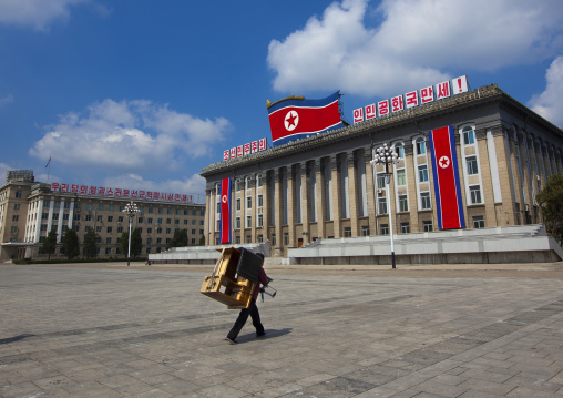 North Korean man carrying a wooden desk on his back in Kim il Sung square, Pyongan Province, Pyongyang, North Korea