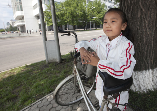 North Korean girl in the street with a bicycle, Pyongan Province, Pyongyang, North Korea