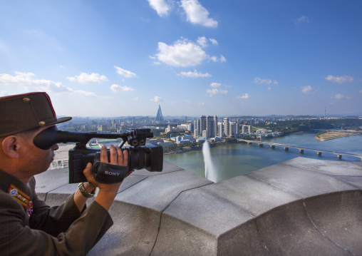 North Korean soldier filming the city from the top of Juche tower, Pyongan Province, Pyongyang, North Korea
