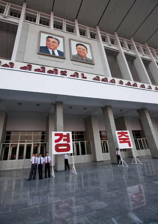 Propaganda billboards in front of the portraits of the Leaders during a mass dance on the day of the foundation of the republic, Pyongan Province, Pyongyang, North Korea
