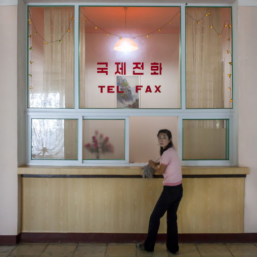 North Korean woman in front of a telephone and fax corner in an hotel, South Hamgyong Province, Hamhung, North Korea