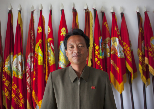 North Korean farm leader in front of political flags, South Hamgyong Province, Hamhung, North Korea