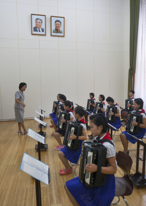 Accordion classroom with North Korean students in Mangyongdae children's palace under the official portraits of the Dear Leaders, Pyongan Province, Pyongyang, North Korea