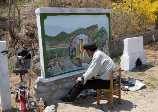 Old North Korean man painting in the countryside, North Hamgyong Province, Chilbo Sea, North Korea