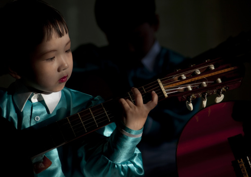 North Korean young boy playing guitar in Tchang Gwang school, North Hamgyong Province, Chongjin, North Korea