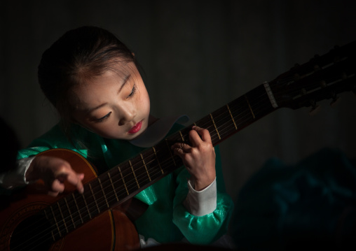 North Korean young girl playing guitar  in Tchang Gwang school, North Hamgyong Province, Chongjin, North Korea