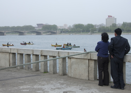 Couple looking at small boats on Taedong river, Pyongan Province, Pyongyang, North Korea