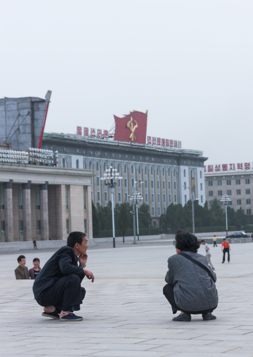 North Korean men squatting on Kim il Sung square, Pyongan Province, Pyongyang, North Korea