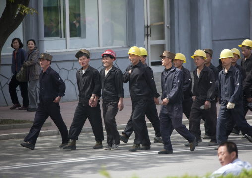 North Korean workers with yellow helmets walking in the street, Pyongan Province, Pyongyang, North Korea