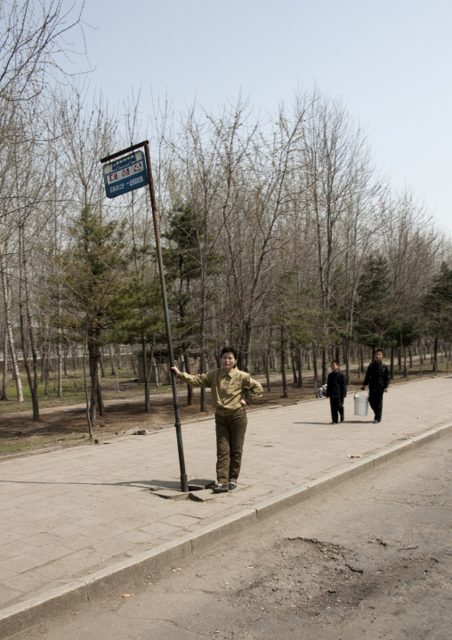 North Korean woman waiting at the bus stop, Pyongan Province, Pyongyang, North Korea