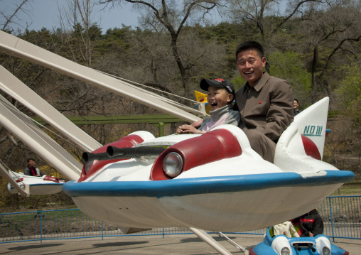 North Korean people having fun on a flying saucer attraction in Taesongsan funfair, Pyongan Province, Pyongyang, North Korea
