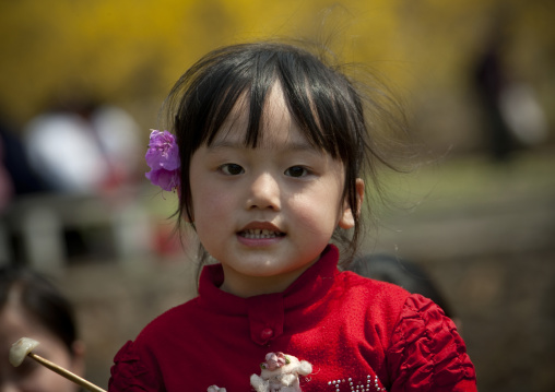 North Korean girl in a park with a flower on the ear, Pyongan Province, Pyongyang, North Korea