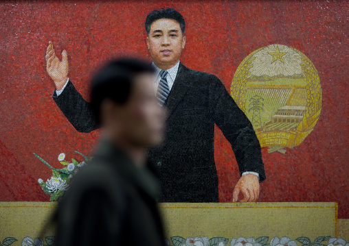 North Korean man passing in front of a Kim il Sung on a propaganda mosaic in the subway, Pyongan Province, Pyongyang, North Korea