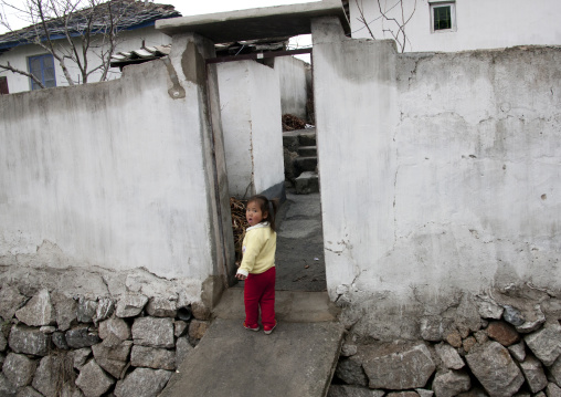 Little North Korean girl at the entrance of her house in the countryside, North Hwanghae Province, Kaesong, North Korea
