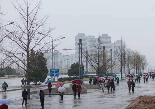North Korean people walking in the street under the rain, Pyongan Province, Pyongyang, North Korea