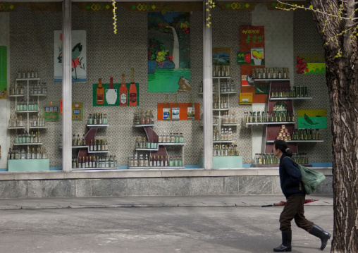 North Korean woman passing in front of a drinks shop, Pyongan Province, Pyongyang, North Korea