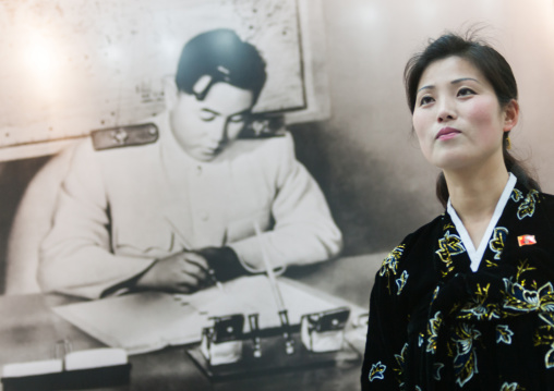 North Korean woman in front of a Kim il Sung propaganda picture in Jonsung revolutionary museum, Pyongan Province, Pyongyang, North Korea