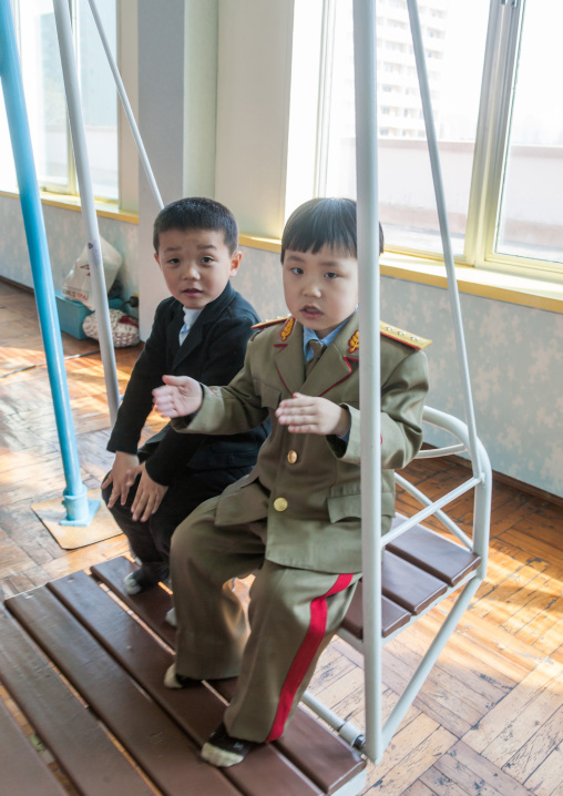 North Korean boys swinging in Kwangbok primary school, Pyongan Province, Pyongyang, North Korea