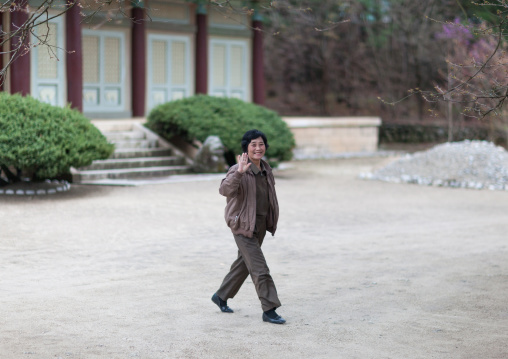 North Korean woman waving in a temple courtyard, Hyangsan county, Mount Myohyang, North Korea