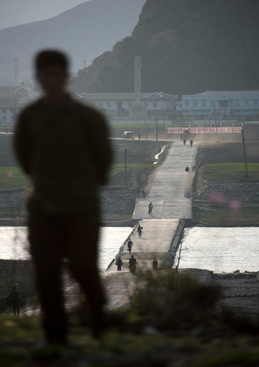 North Korean man overlooking a small bridge on a river, Kangwon Province, Wonsan, North Korea