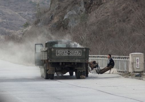 North Korean men repairing a smoking vapor truck on a highway, Kangwon Province, Wonsan, North Korea