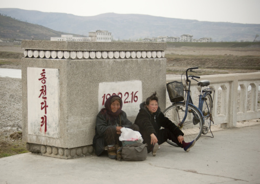 North Korean women leaning on a bridge in the countryside, Kangwon Province, Wonsan, North Korea