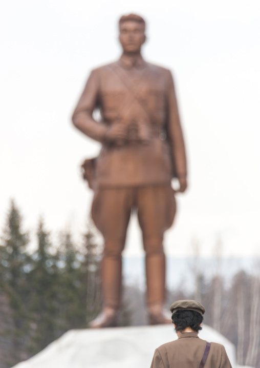 North Korean guide in mount Paektu in front of a Kim il Sung statue, Ryanggang Province, Samjiyon, North Korea