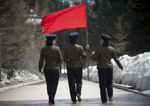 North Korean students with a red flag walking on the steps of the nation's heroes in mount Paektu, Ryanggang Province, Samjiyon, North Korea