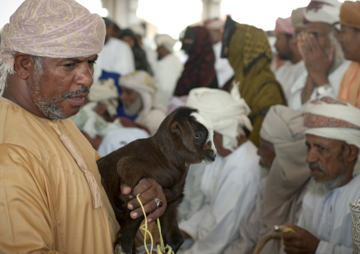 Man Holing A Brown Lamb In Sinaw Market, Oman