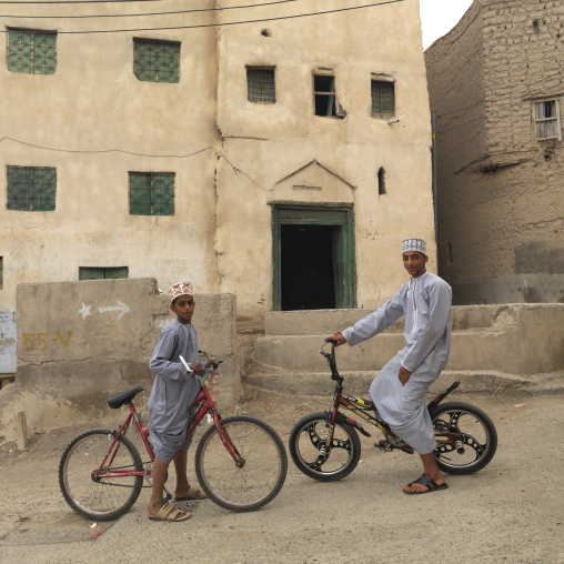 Two Boys Riding Bikes In Front Of The Residence , Nizwa, Oman