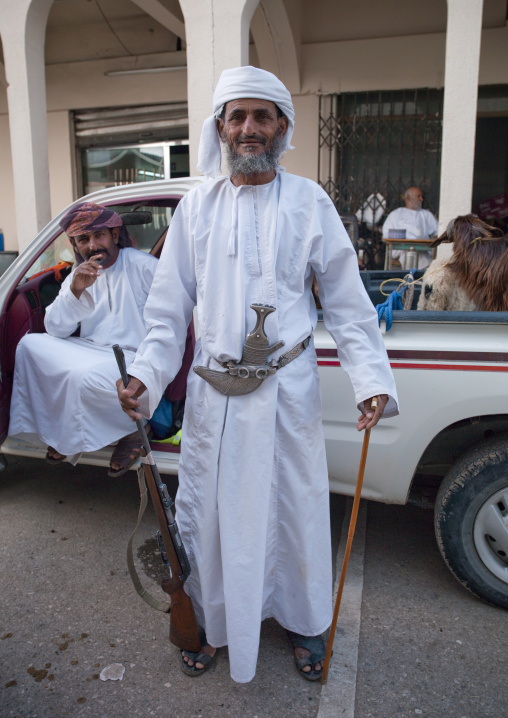 Old Man Wearing A Khanjar And Holding A Gun In The Right Hand While A Stick In The Left Hand, Ibra, Oman