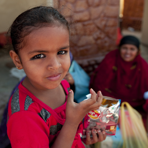 Bedouin Little Girl Holding A Pack Of Crisps, Ibra, Oman