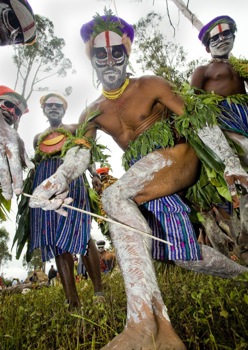 Highlander warrior puting makeup on his legs during sing-sing, Western Highlands Province, Mount Hagen, Papua New Guinea