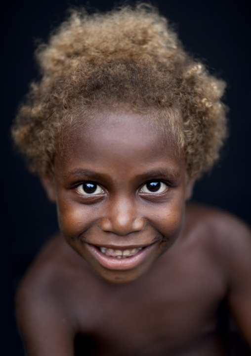 Portraot of a smiling boy with blonde hair, New Ireland Province, Langania, Papua New Guinea