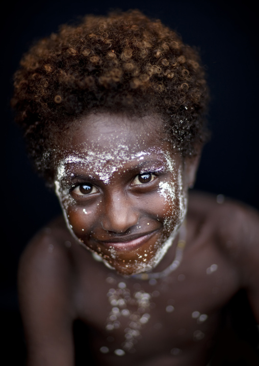 Portraot of a smiling boy with traditional makeup, New Ireland Province, Langania, Papua New Guinea