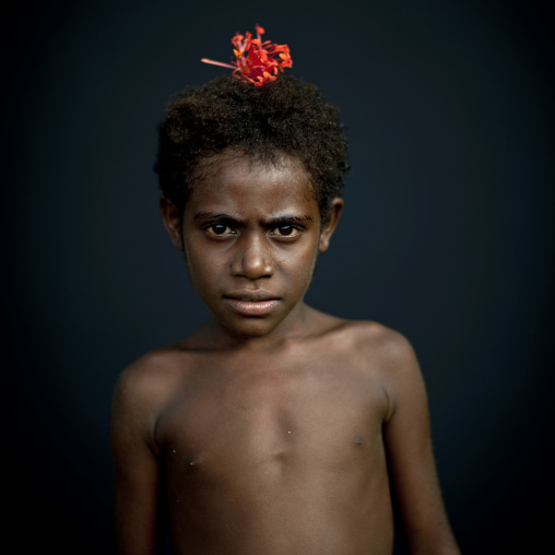 Portrait of a boy with a red flower in the hair, New Ireland Province, Langania, Papua New Guinea