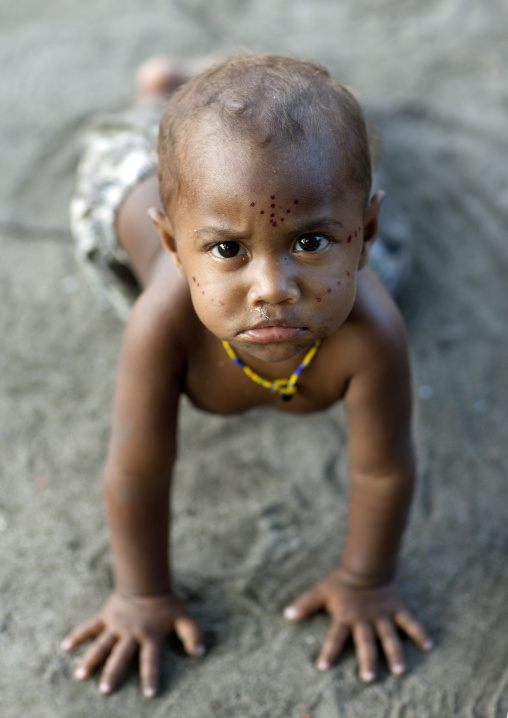 baby girl with blonde hair walking on his hands, New Ireland Province, Langania, Papua New Guinea