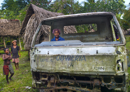 Children playing in a car wreck, Milne Bay Province, Trobriand Island, Papua New Guinea