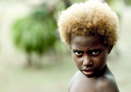 Portrait of a boy with blonde hair looking at camera, New Ireland Province, Langania, Papua New Guinea