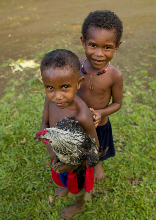 Boys with a chicken, Milne Bay Province, Trobriand Island, Papua New Guinea