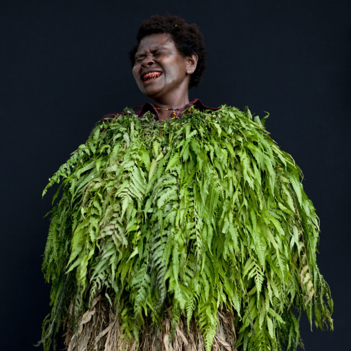 Woman with vegetal dress laughing, New Ireland Province, Langania, Papua New Guinea