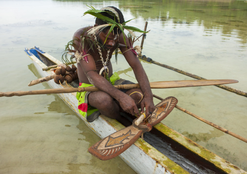 Man on a pirogue making a shark calling, New Ireland Province, Kavieng, Papua New Guinea