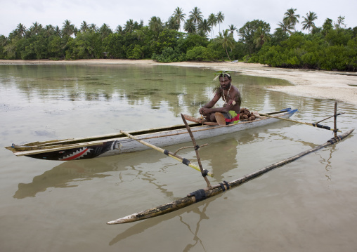 Man on a pirogue making a shark calling, New Ireland Province, Kavieng, Papua New Guinea