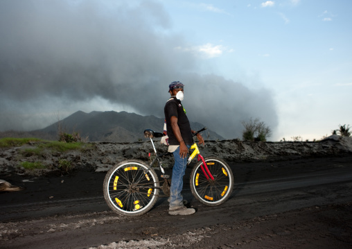 Boy with his bike in tavurvur volcano, East New Britain Province, Rabaul, Papua New Guinea