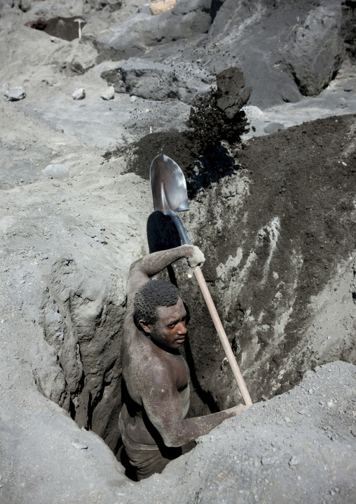 Man digging to find megapode birds eggs in Tavurvur volcano ashes, East New Britain Province, Rabaul, Papua New Guinea
