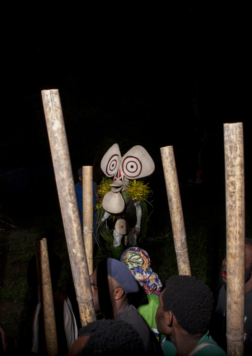Dancer with a giant mask with musicians during a Baining tribe fire dance, East New Britain Province, Rabaul, Papua New Guinea